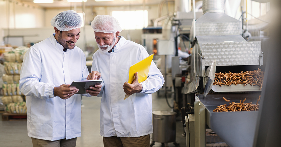 Two smiling chemists at work in a factory