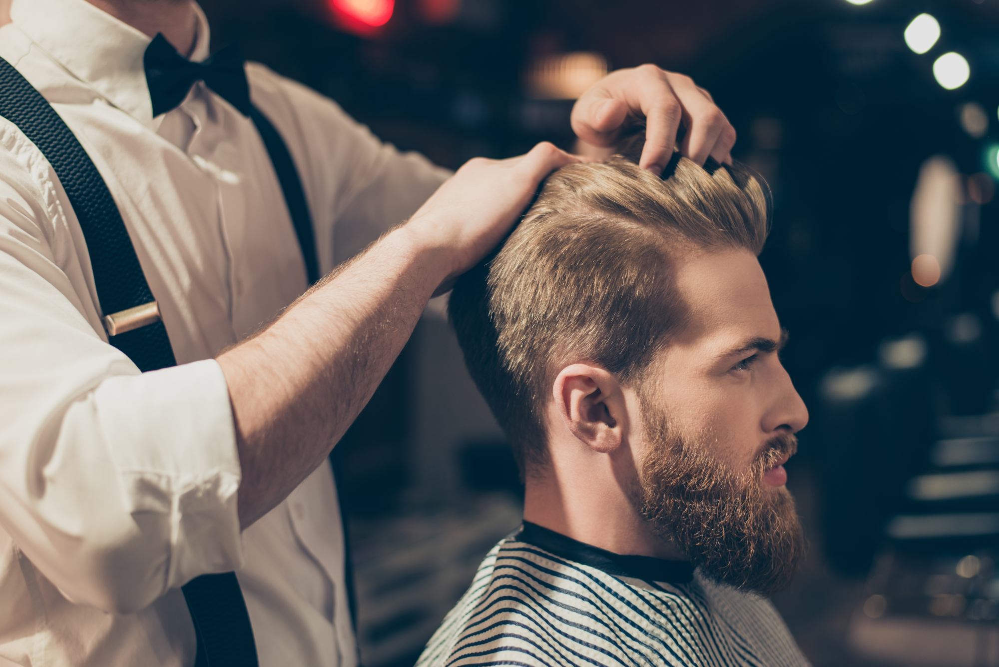 A man getting his hair done at a barber shop